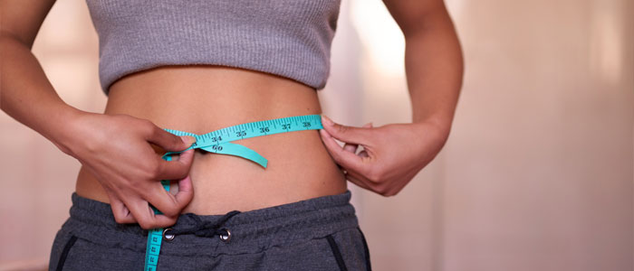 woman holding tape measure around waist